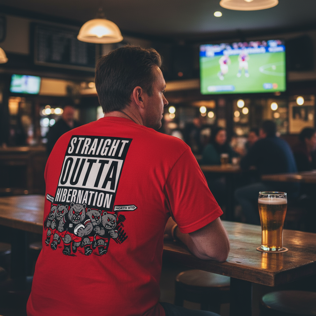 Man wearing a red NRL North Sydney Bears Straight Outta Hibernation t-shirt with text sitting at a bar.
